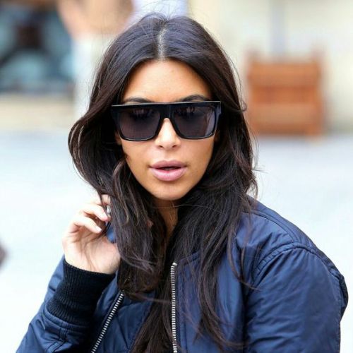 Kim Kardashian avec des lunettes de soleil noir forme trapèze